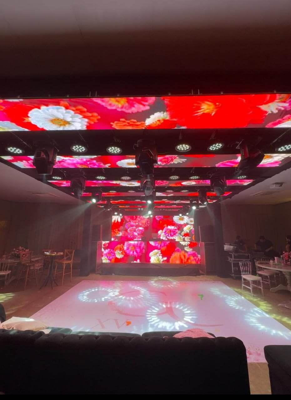 Pista de dança moderna com painéis de LED de alta definição instalados no teto e no fundo, exibindo projeções visuais coloridas.