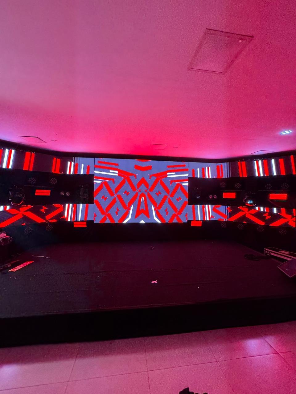 Cenário de evento corporativo ou show com painel de LED wide screen exibindo grafismos geométricos.